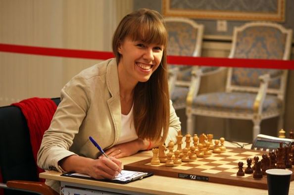 olga-smiling-at-chess-board-after-round-10.jpg