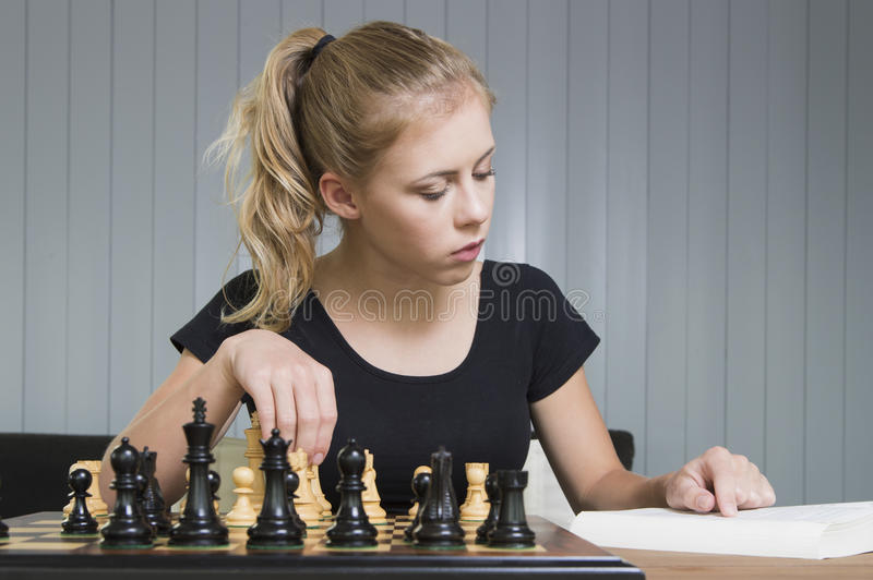 teenager-play-chess-studying-moves-book-57953502.jpg