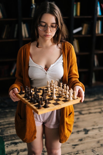 vertical-portrait-thoughtful-sexy-young-woman-elegant-eyeglasses-holding-hands-chess-boar-looking-chessboard_482921-7730.jpg