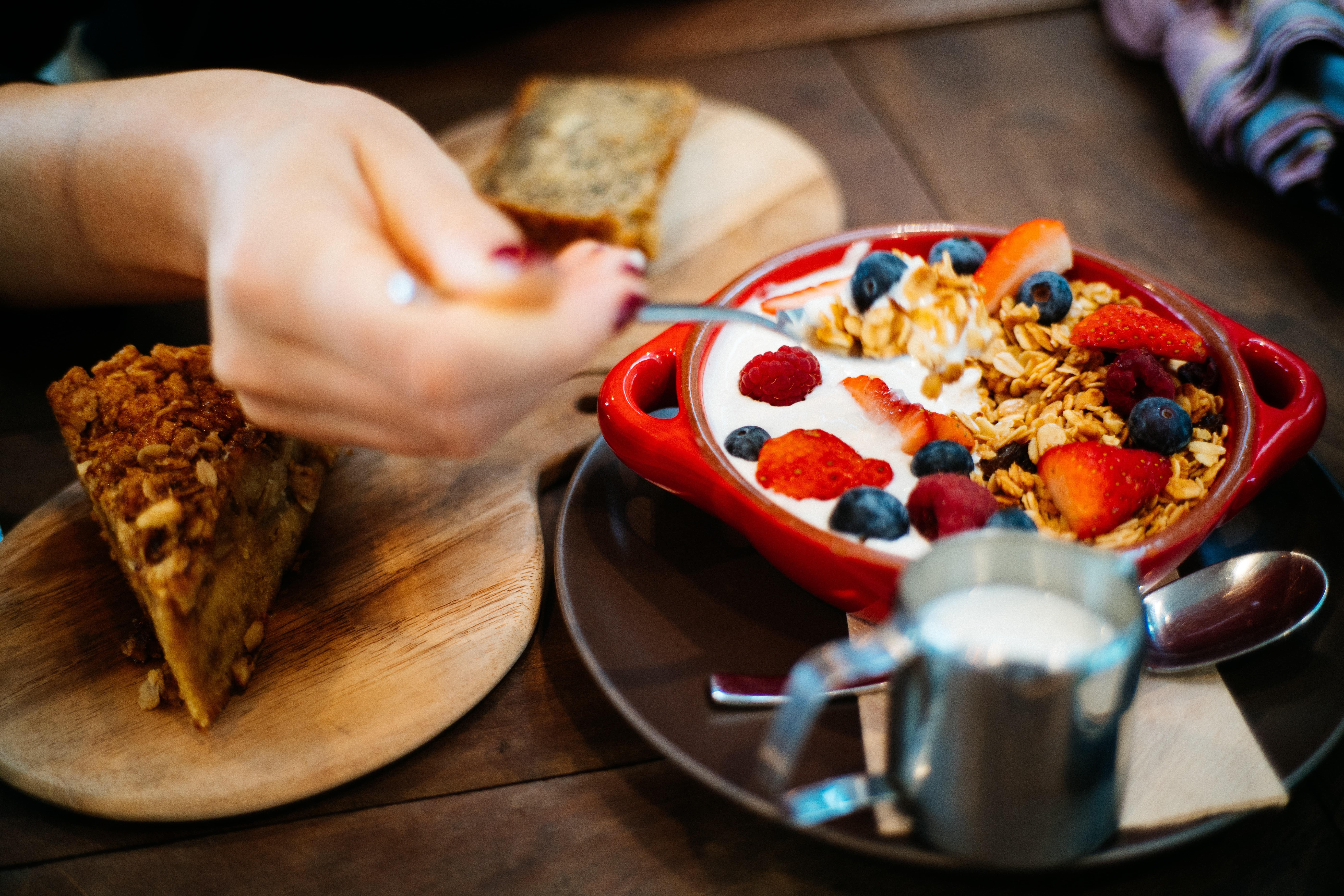 person-holding-spoon-and-round-red-ceramic-bowl-with-1065030-min.jpg