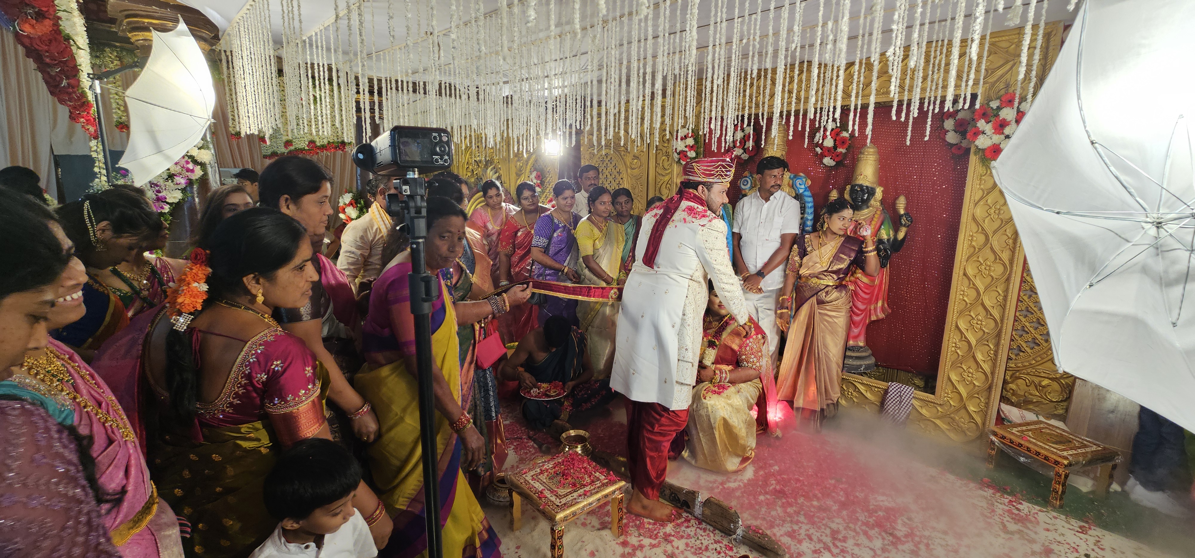 Vőlegényünk egy arany nyakláncot akaszt arája nyakába.