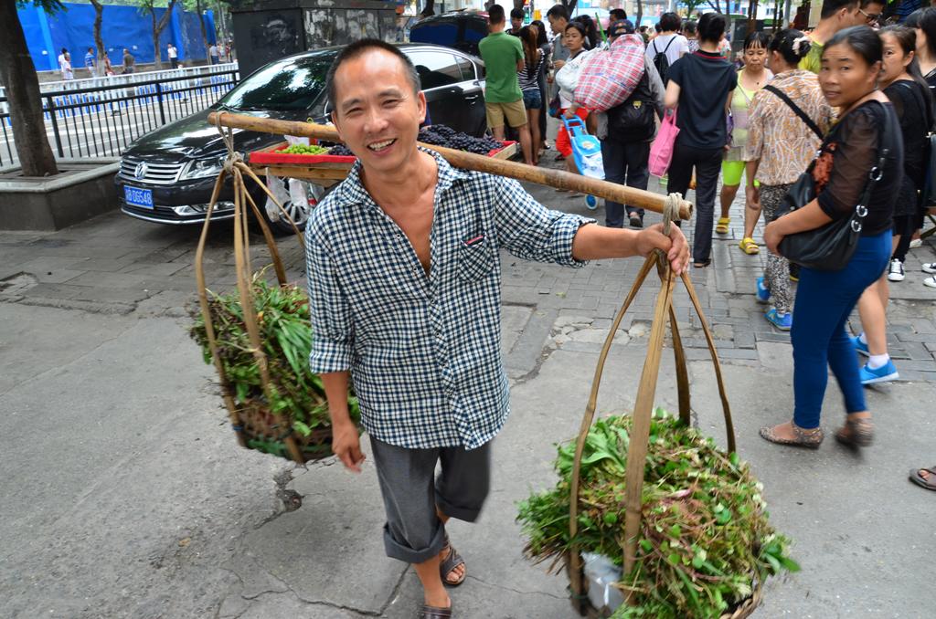 Hegyvideki varoskent, Chongqing utcainak allando szereploje a vallra vetett bambusz rudon terhet szallito ember.