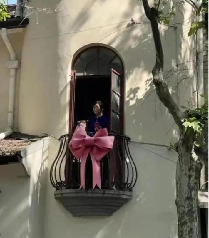 Elmesélek egy érdekes sztorit: Az erkélyes lakásban egy 80 éves mamika élte csendes hétköznapjait, több mint 30 évig. Egyik kínai újév során egy hatalmas rózsaszín masnit akasztott a kovácsoltvas erkélyre, ami tulajdonképpen szomszédja ötlete volt. Sokáig nem történt semmi, aztán egyszercsak a május 1 -jei ünnep alatt valaki videót készített amikor a mami az erkélyről kedvesen integetett a turistáknak.