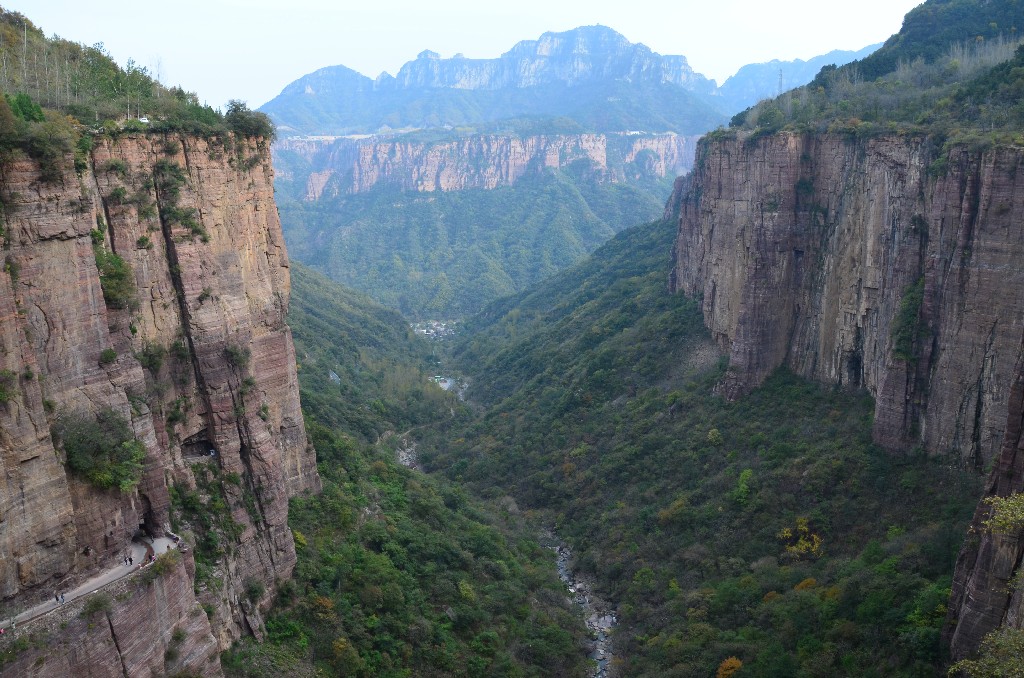 A vörös szikla szurdoka (The Great Gorge of Red Rock Cliff)<br />A gyönyörű vörös sziklákból, vízesésekből és zöld növényekből álló szurdok páratlan szépségű.<br />300 méter mély, 500 méter széles és 6000 méter hosszú.<br />Az alja neoarcheai gránitból áll, amely 2.5 -2.8 milliárd évvel ezelőtt keletkezett.<br />A szurdok a 120 millió évvel ezelőtti kéregmozgások hatására alakult ki.<br />A sziklafal 1.4 -1.0 milliárd éves, és a mezoproterozoikum korszakban keletkezett rózsaszínes kvarcit alkotja.<br />A 65 millió évvel ezelőtti kéregmozgások és az erózió miatt fokozatosan alakult ki a Taihang hegy mai formája.<br />Számos természetes barlang található, köztük a Bailong-barlang látogatható