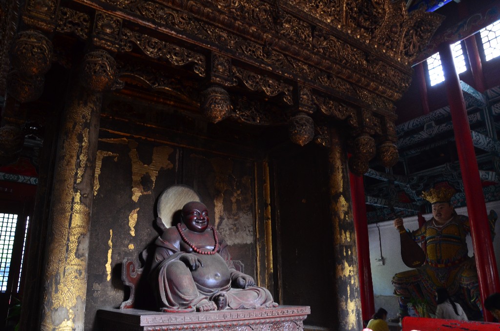Maitreya, vagy Nevető Buddha<br /><br />Maitreyat a négy „Mennyei Király” szobra őrzi, mindegyik az univerzum egynegyedét képviseli. A keleti oldalt Chigua (az állam őre) uralja egy pipával, a nyugati oldalt Guangmu (éleslátó) egy sárkánnyal a kezében, a déli irányt Zengzhang (növekedés védelmezője) képviseli, kezében esernyő, az északi irányt pedig a pagodát hordozó Duowen (tudásmegőrző) képviseli.