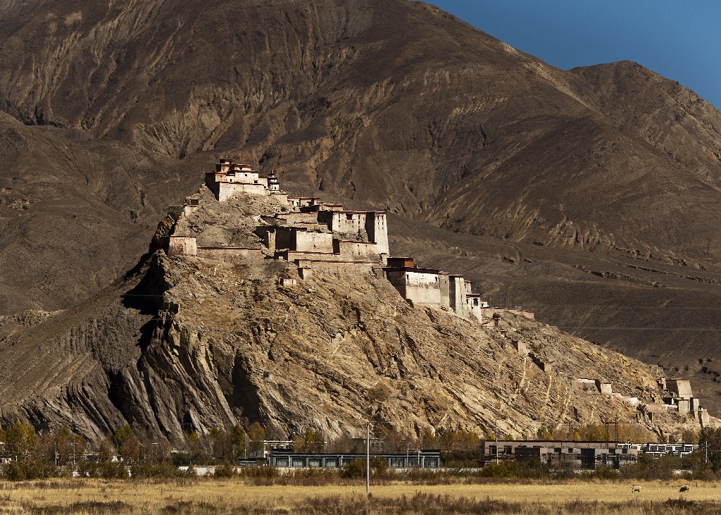 A Gyantse erőd magasan a város felett áll egy hatalmas szürkés-barna sziklán.