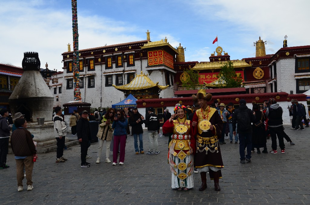 Az utcákon tibeti jelmezbe öltözött kínai turisták fényképezkednek. Irodák sora kínálja szolgáltatásait: ruhát, parokát, sminket és fotóst lehet tőlük rendelni/bérelni.