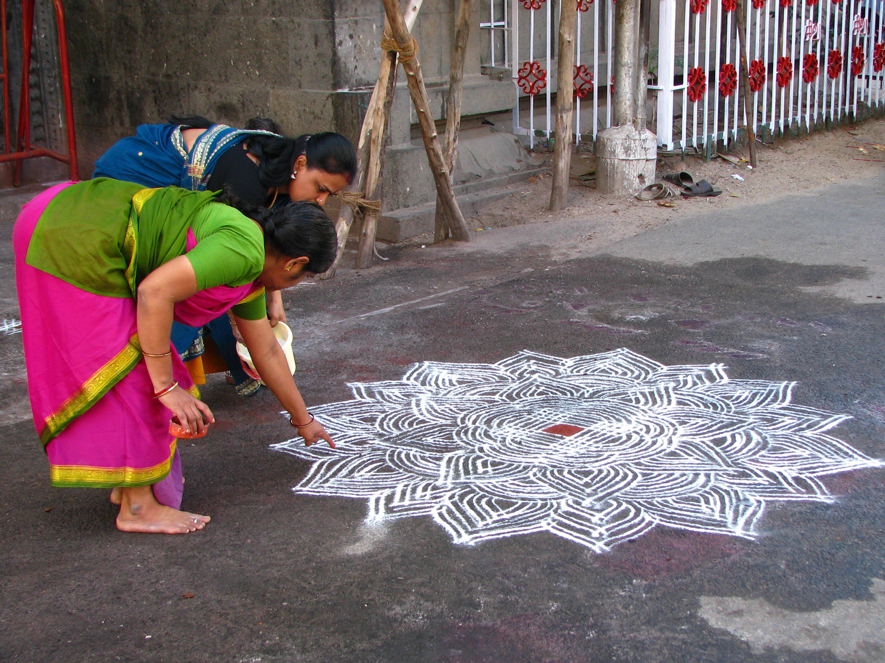 A tamilok rizsporból készült Kolam nevű színes geometrikus mintákkal díszítik otthonaik vagy boltjaik bejáratát.<br />A művészeti rituálét a hindu tamil nők hozták létre, mai napig gyakorolják és ápolják a hagyományt.<br />Minden nap hajnal előtt, a Brahma muhurtam idején (ez az az idő, amikor Brahma és minden más istenség leszáll a földre) és néha szürkület előtt nők milliói falvakban és városokban, a házak, templomok és üzletek küszöbén rajzolnak a gondosan lesöpört talajon. A tamil kultúrában a küszöb nagy jelentőséggel bír, mivel a belső és a külső találkozási pontja.