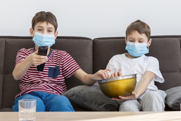 children-with-medical-masks-watching-tv-eating-popcorn_23-2148501335.jpg