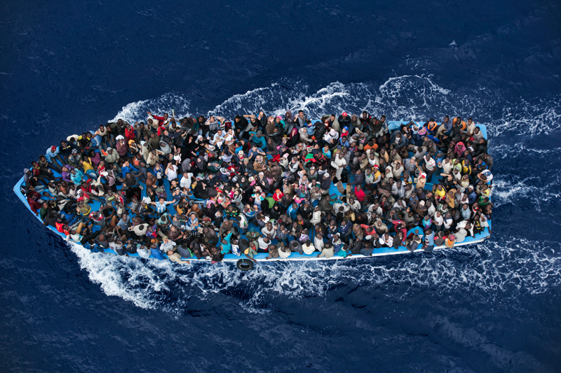 eonéban.<br />Massimo Sestini<br />Hír<br />2. díj, egyedi<br />Massimo Sestini<br />Olaszország<br />Menekültek zsúfolódnak egy hajón körülbelül 25 kilométerre a líbiai<br />partoktól azt megelőzően, hogy a Mare Nostrum művelet keretében<br />megmenti őket egy olasz fregatt. A menekülteket felkutató és megmentő<br />programot az olasz kormány dolgozta ki az után, hogy 2013 végén<br />Lampedusa szigeténél több száz menekült fulladt a vízbe. 2014-ben<br />drámaian megemelkedett azok száma, akik az életük kockáztatásával<br />próbáltak átjutni Olaszországba a Földközi-tengeren. A Mare Nostrum<br />művelet keretében civil szervezetek az életmentésen túl azon is<br />fáradoztak, hogy a menekültek orvosi, kulturális és egyéb segítséghez<br />jussanak. A tengerésztisztek felhatalmazást kaptak az embercsempészek<br />letartóztatására és a hajók lefoglalására. Egyéves működése alatt a Mare<br />Nostrum művelet 330 embercsempészt állított bíróság elé és megmentette<br />több mint 150 000 ember életét – az emberek legalább negyede Szíriából<br />menekült. A Mare Nostrum program októberig működött, akkor felváltotta a<br />Triton, az Európai Unió külső határvédelmi szervezetének, a Frontexnek<br />az irányításával. Ez utóbbi program nem mentő, hanem elsősorban<br />határőrizeti jellegű
