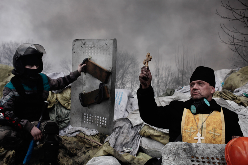 Vezető hír<br />2. díj, sorozat<br />Jérôme Sessini<br />Franciaország, Magnum Photos a De Standaard számára<br />2013 novemberében az ukrán fővárosban, Kijevben tüntetések kezdődtek,<br />amikor Viktor Janukovics elnök nem írta alá a társulási szerződést az<br />Európai Unióval, mert az Oroszországhoz fűződő kapcsolatok erősítését<br />részesítette előnyben. Több ezer Európa-barát tüntető gyűlt össze a város<br />Majdanként ismert Függetlenség terén és hónapokig el sem mozdult<br />onnan. A folyamatos erőszak február 18-án tetőzött. A következő három<br />nap alatt több mint hetven tüntető és rendfenntartó halt meg, miközben<br />mindkét fél a másikat vádolta azzal, hogy lőni kezdett. Janukovics elnök<br />február 21-én elmenekült az országból, májusban az Európa-barát Petro<br />Porosenkót választották elnökké.