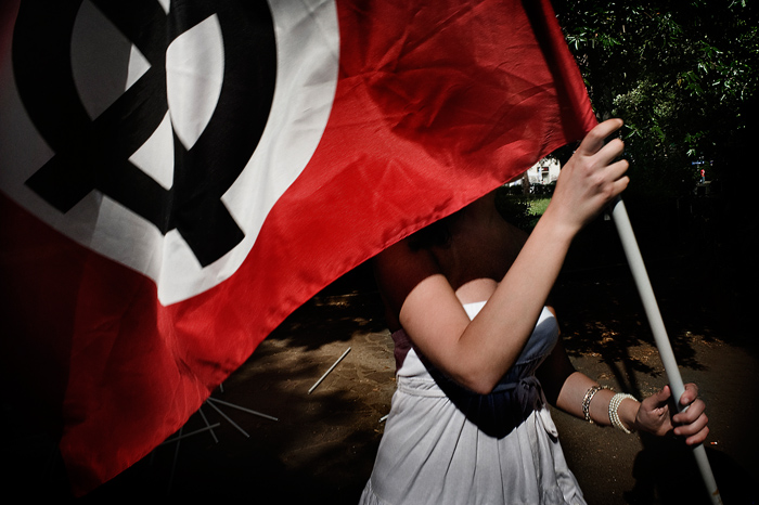 Fiatal lány zászlóval egy Berlusconi elleni tüntetésen (2009. május).<br />