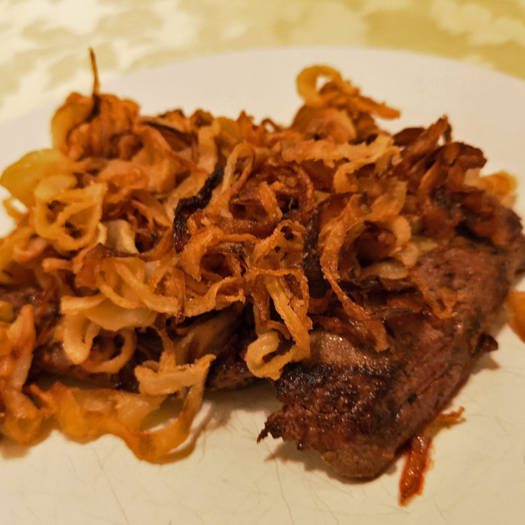 A klasszikus hagymás rostélyos receptje: rengeteg sült hagymakarika takarja be az omlós húst