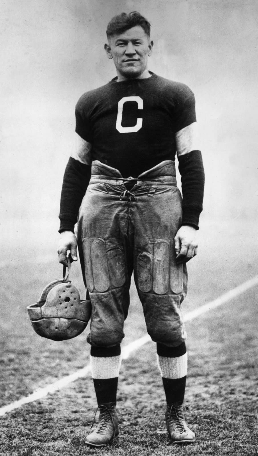 circa_1915_american_athlete_jim_thorpe_posing_in_a_football_uniform_on_a_field.jpg