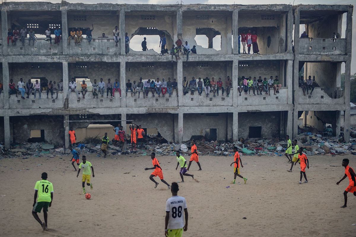 somali_people_play_football_in_the_smoky_air_due_to_burning_garbage_at_a_destroyed_and_abandoned_secondary_school_in_mogadishu.jpg