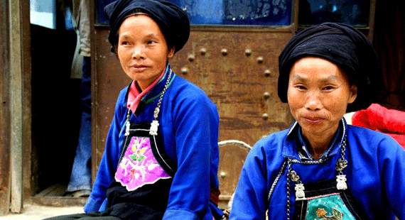 Hagyományos ruházatban feszítő idősebb zhuang asszonyok. A népviselet ma már nem nagyon jellemző, elsősorban turisztikai célokat szolgál.