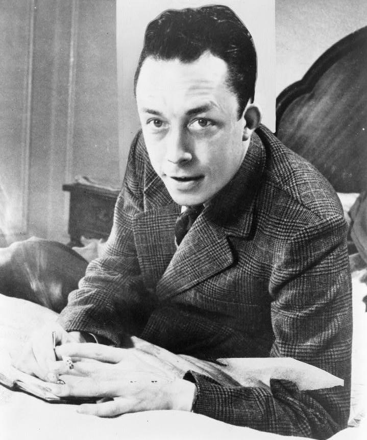 albert_camus_gagnant_de_prix_nobel_portrait_en_buste_pose_au_bureau_faisant_face_gauche_cigarette_de_tabagisme.jpg