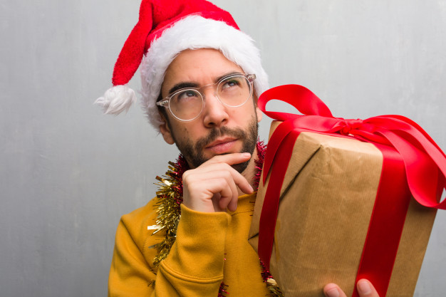 young-man-sitting-with-gifts-celebrating-christmas-thinking-about-an-idea_1187-8311.jpg