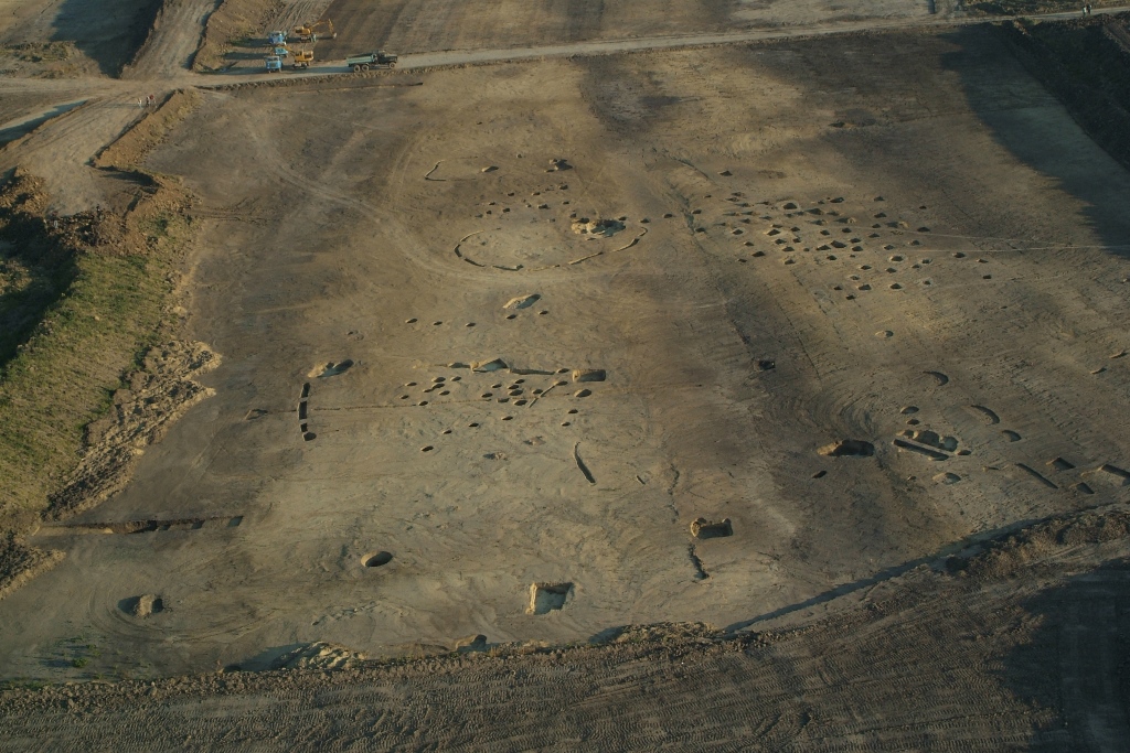 1. kép: A Rákóczifalva-Bivaly-tó, Bagi-föld 1/C. lelőhelyen feltárt rézkori temető légi fotója. A kép középső részén a temető két sírcsoportja, míg a kép alsó részén egy szarmata település objektumai (kerek gödrök, árkok) láthatók (Fotó: Kozma Károly)