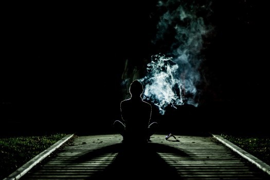 man-sitting-on-boardwalk-and-smoking-cigarette.jpg