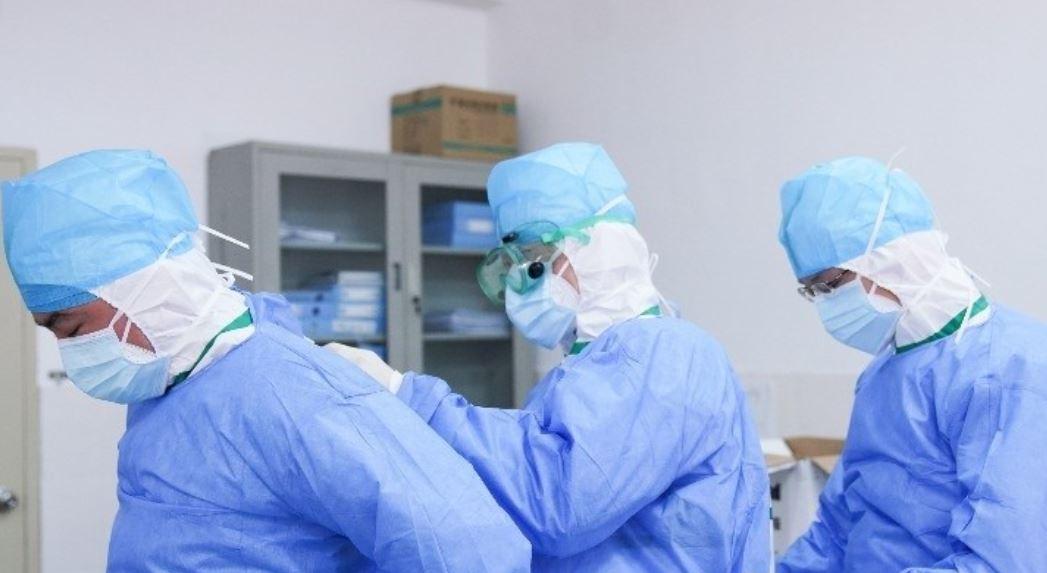 trabajadores-medicos-se-ayudan-mutuamente-para-ponerse-trajes-protectores-contra-el-coronavirus-en-un-vestuario-en-el-hospital-municipal-de-zhangzhou-en-zhangzhou.jpeg