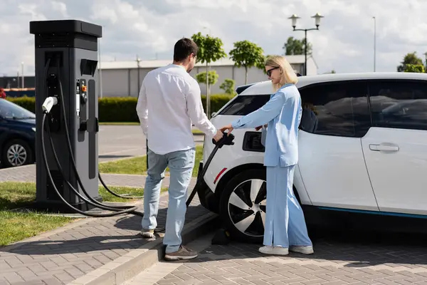 depositphotos_729544270-stock-photo-couple-charging-electric-car-station.jpg