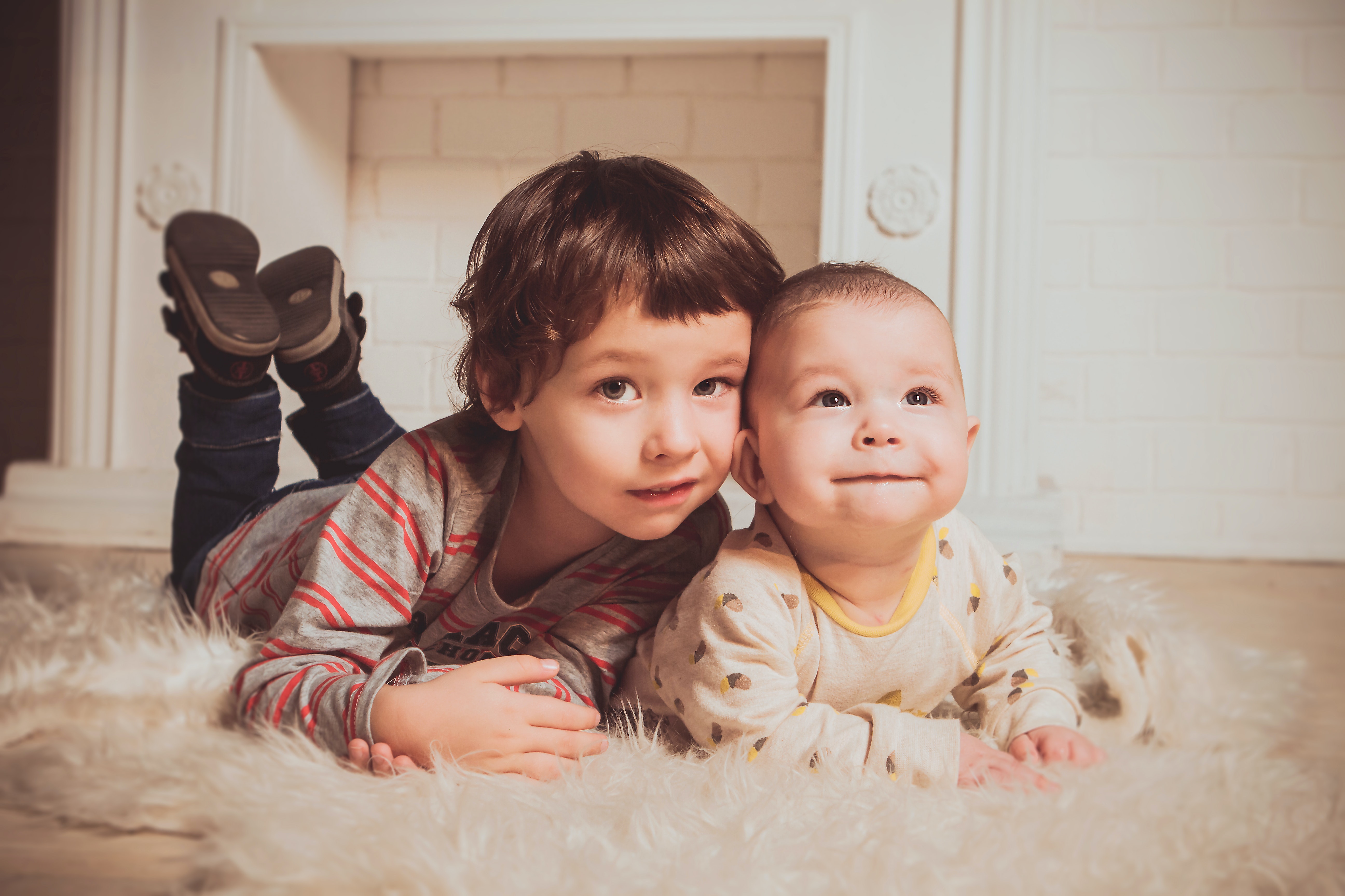 boy-lying-beside-baby-on-mat-1648379.jpg