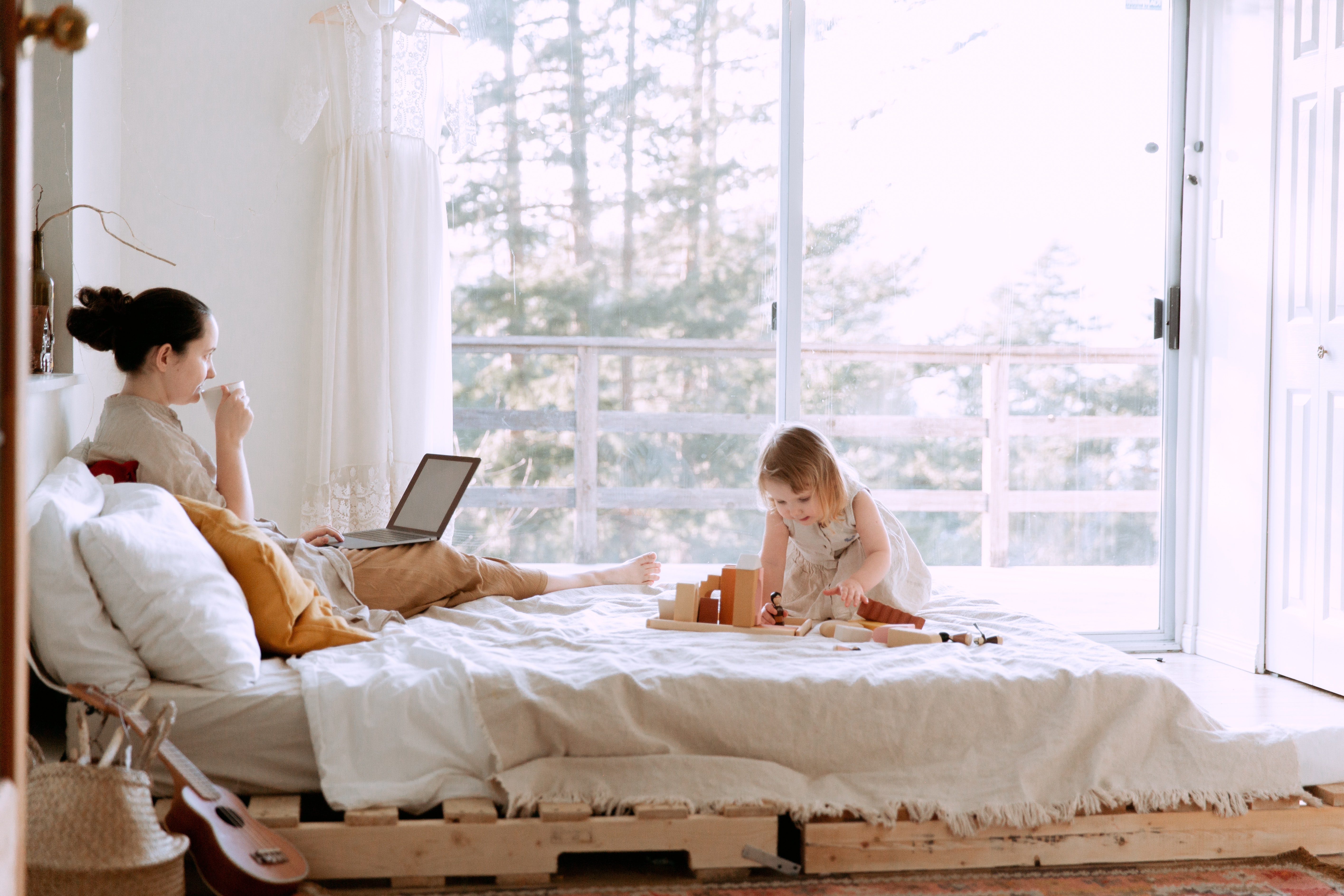 woman-using-laptop-while-daughter-playing-with-constructor-3975644.jpg