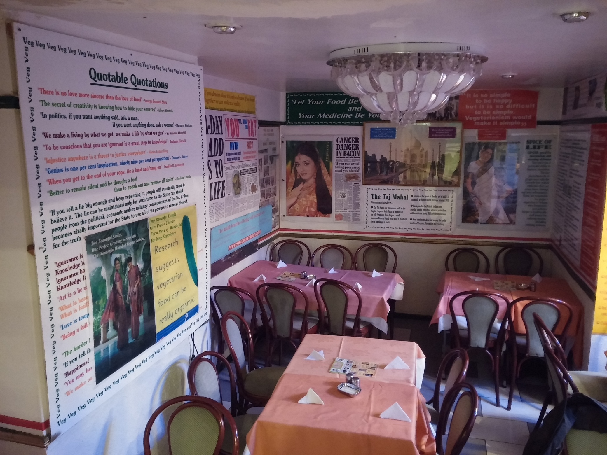 Családias berendezésű kis étterem-belső, amelynek a falai tele vannak a vegán élet propaganda-üzeneteivel