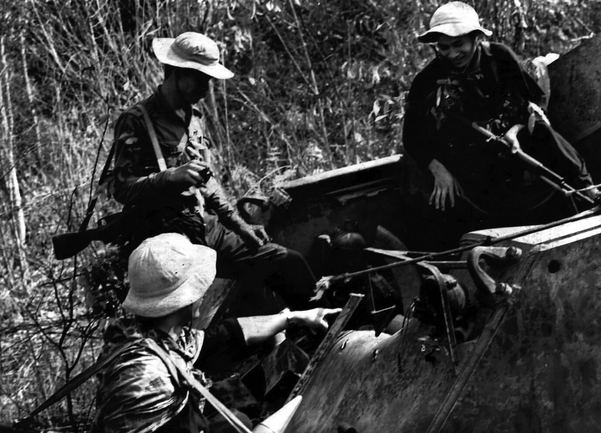 Vietkong gerillák SzkSz-szel egy szétlőtt M-113-as PSZH-n