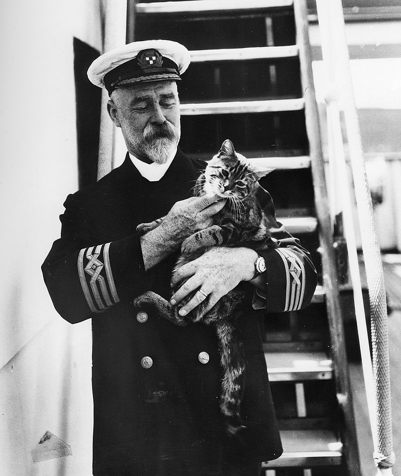 captain_a_j_hailey_in_uniform_with_a_cat_on_the_first_c_p_r_m_s_empress_of_canada.jpg