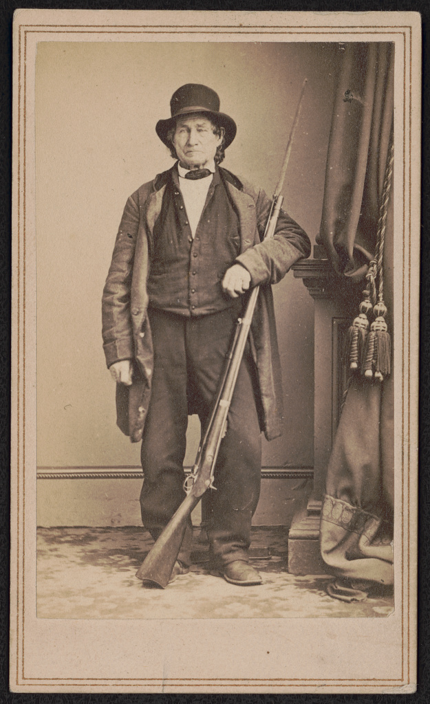 john_l_burns_veteran_of_the_war_of_1812_civilian_who_fought_at_the_battle_of_gettysburg_with_union_troops_standing_with_bayoneted_musket_from_photographic_negative_in_brady_s_national_lccn2017659617.jpg