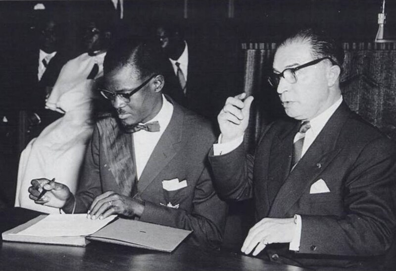 patrice_lumumba_signs_the_document_granting_independence_to_the_congo_next_to_belgian_prime_minister_gaston_eyskens.jpg
