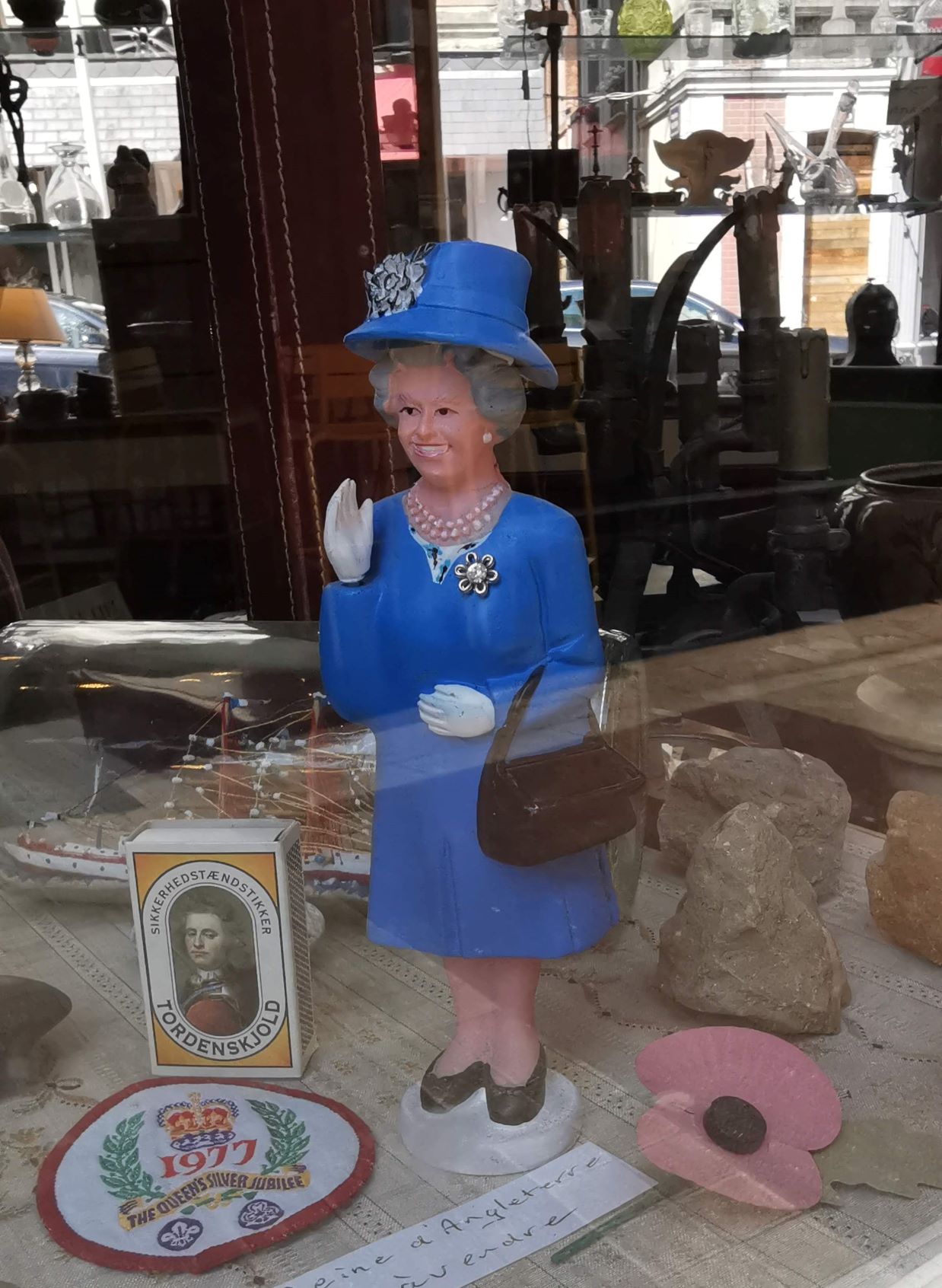 Ez egy régiségbolt kirakata. Mindent lehet kapni, még integető angol királynőt is.