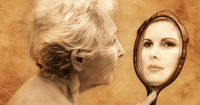 elderly-woman-holding-hand-mirror-reflecting-young-woman.jpg
