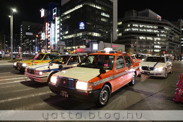 a dugóban a Tokyo Stationnél este 3 sorban állnak meg a taxik, hogy kiszálljanak az utasok